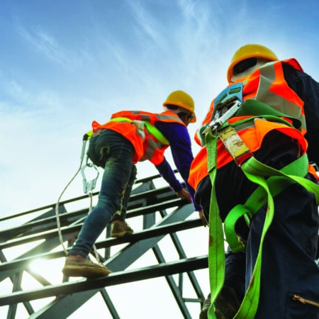 workmen in harnesses working at height